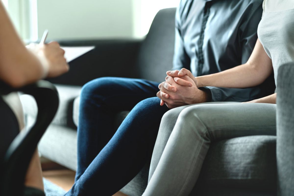 Couple holding hands sitting with psychiatrist