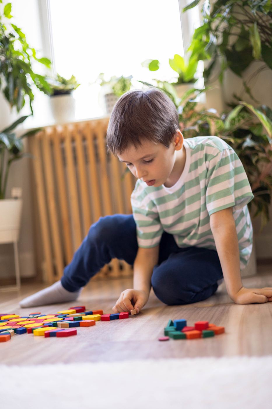 Child arranging colorful wooden blocks during autism assessment for children.